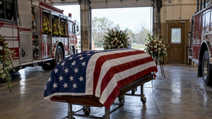 Flag-draped casket in a firehouse bay