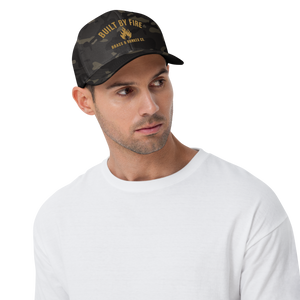 Man wearing a black multi-cam baseball cap with 'BUILT BY FIRE', 'BRASS & BUNKER CO'