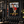 Black gym banner featuring a tattooed firefighter pin-up with “BRASS & BUNKER CO. DROPPING TONES” and “ALL GRIT. NO QUIT.”
