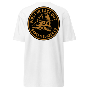 White short-sleeve t-shirt shown from the back, featuring a large circular graphic print in black and tan. The graphic depicts a skull wearing a firefighter helmet with flames, and the text 'FIRST IN LAST OUT BRASS & BUNKER CO'.